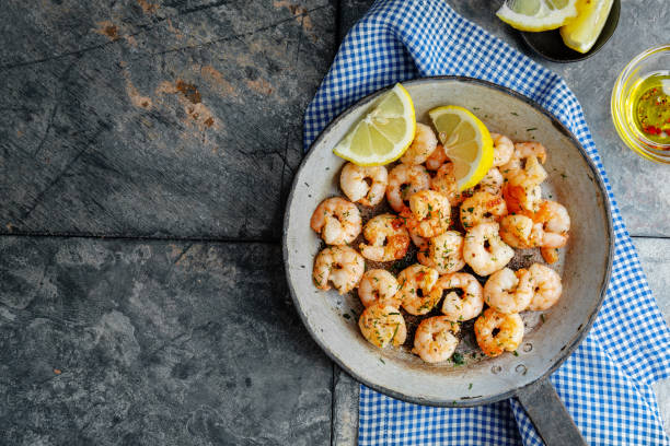 istock Tasty appetizing fried shrimps on pan on dark stone background. 1351038817
