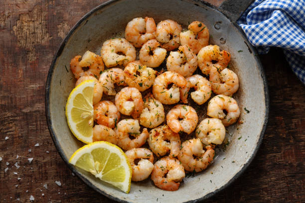 istock Tasty appetizing fried shrimps on pan on dark stone background. 1351039133