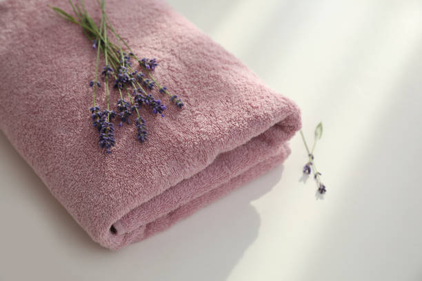istock Folded clean towel and lavender flowers on white table, closeup 1351039936