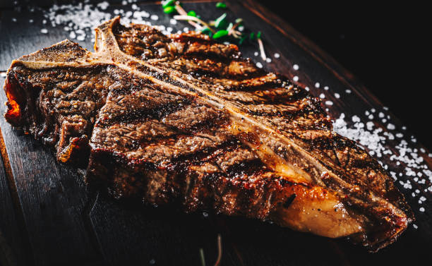 istock Grilled T-bone Steak on bones on wooden board on dark background 1351041809