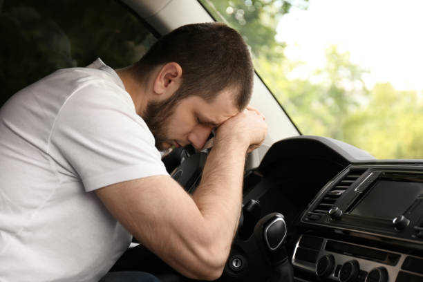 istock Tired man sleeping on steering wheel in his car 1351041833