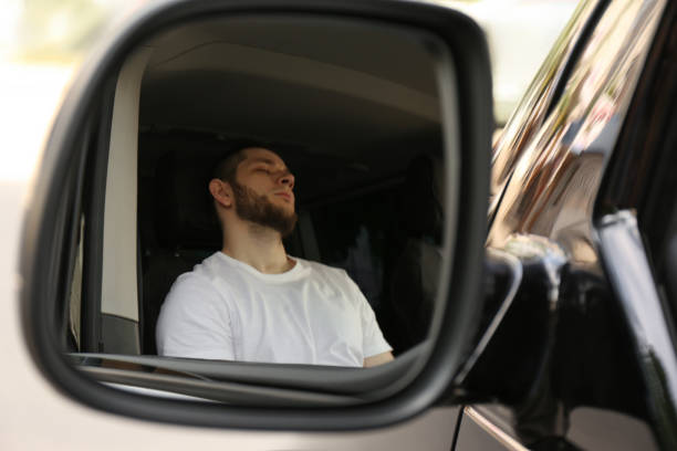 istock Tired man sleeping in his auto, view through car side mirror 1351042217