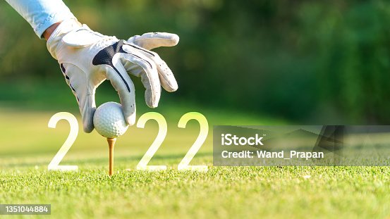 istock Close up hand Golfer woman putting golf ball for Happy New Year 2022 on the green golf for new healthy. 1351044884