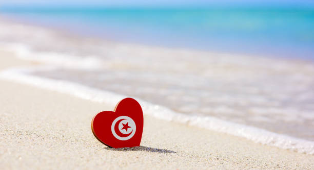 Flag of Tunisia in the shape of a heart on a sandy beach. Flag of Tunisia in the shape of a heart on a sandy beach. The concept of the best vacation in Tunisia djerba stock pictures, royalty-free photos & images