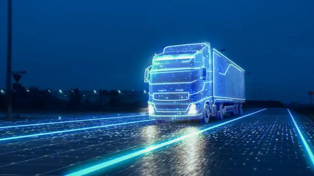 Photo of Futuristic Technology Concept: Autonomous Semi Truck with Cargo Trailer Drives at Night on the Road with Sensors Scanning Surrounding. Special Effects of Self Driving Truck Digitalizing Freeway