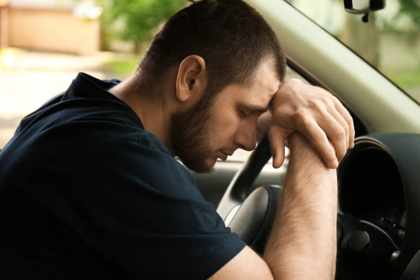 istock Tired man sleeping on steering wheel in his car 1351047432
