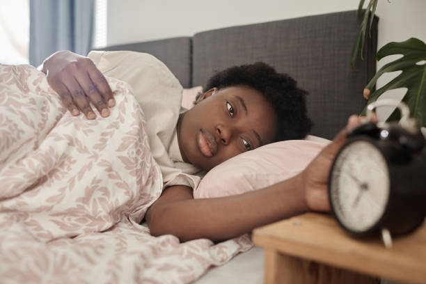 istock Woman waking up with alarm clock 1351047510