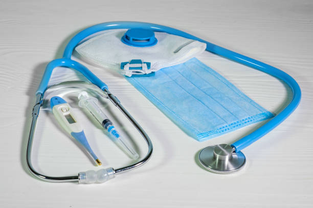 istock Medical protective masks, glasses and stethoscope on a blue wooden surface. Cavid-19 coronavirus infections 1351048657