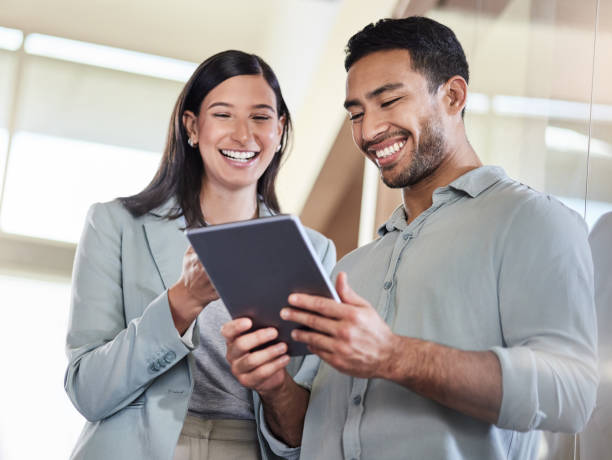 istock Shot of two coworkers using a digital tablet together 1351048689