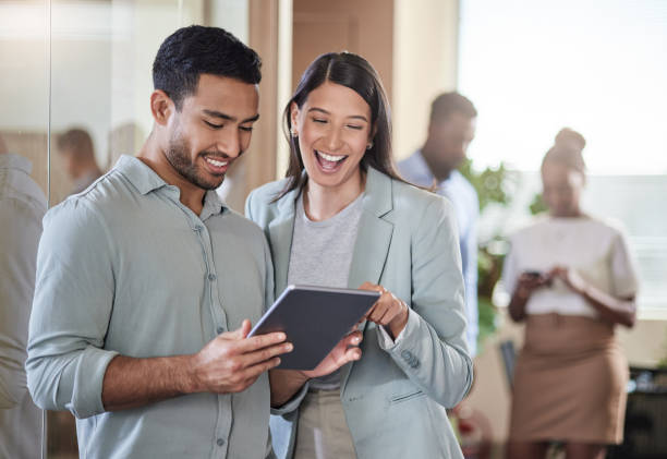 istock Shot of two coworkers talking while using a digital tablet 1351048696