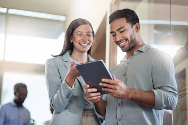 istock Shot of two coworkers talking while using a digital tablet 1351048702