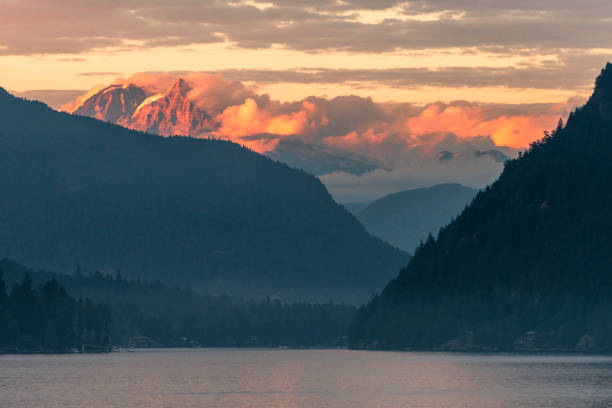 istock Scenic view of mountain range over water, at sunrise 1351048880
