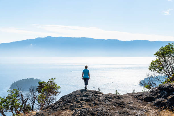 istock Female hiker follows trail along mountain ridge 1351049016