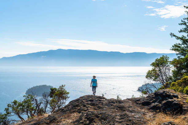 istock Female hiker follows trail along mountain ridge 1351049017