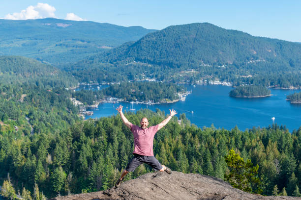 istock Man jumps gleefully in the air, at sunny hike summit 1351049103