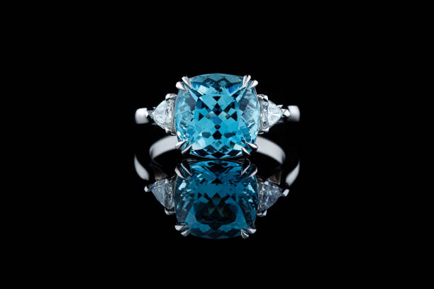 istock Beautiful gold ring with aquamarine and diamonds on a black background 1351052359