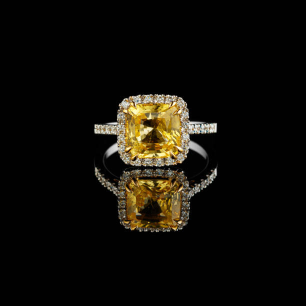 istock Beautiful white gold ring with yellow sapphire and diamonds on a black background 1351052429