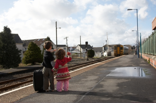 Young boy and girl on platform of railway station