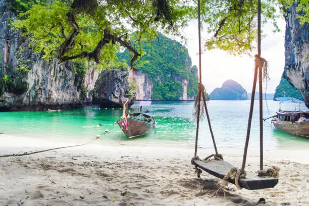 Thai traditional wooden longtail boat and beautiful sand Railay Beach in Krabi province. Hong Island, Thailand.