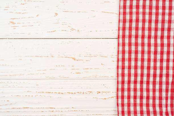 istock Checkered gingham tablecloth napkin on at rustic wooden plank board table background, top view 1351055199