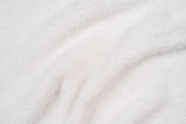 istock Blurred background of soft light tissue. Beige background of plush fabric 1351058574