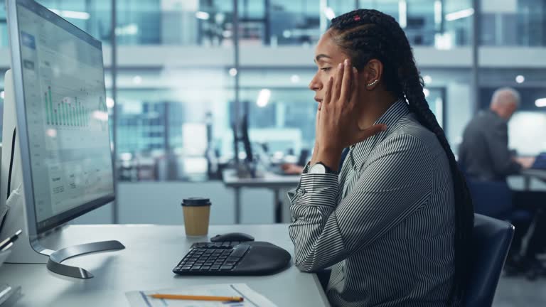 Black Female Corporate Office Worker Feels Stress, Frustration Works on Desktop Computer. Accountant Feeling Project Pressure, Massages Her Head, Works with Statistics, Has Bad Day. Stock Market Crash