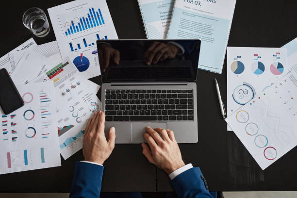 istock Businessman Using Laptop at Desk Top View 1351063299