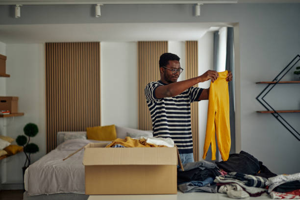 istock Black man with donation box with clothes 1351065492