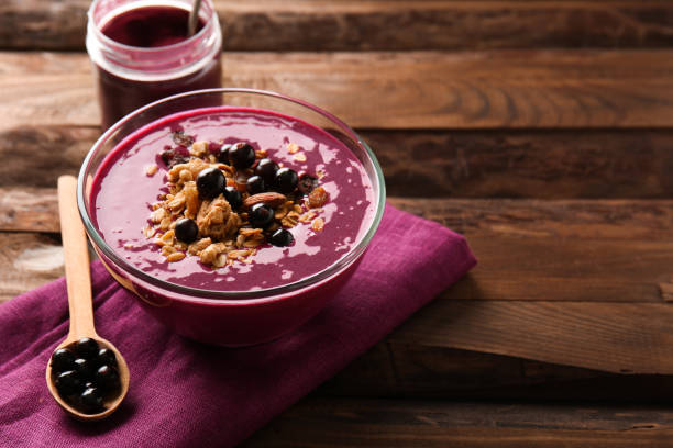 Bowl with tasty acai smoothie on wooden table stock photo