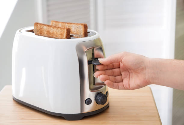 mujer haciendo tostadas para el desayuno - tostadora fotografías e imágenes de stock