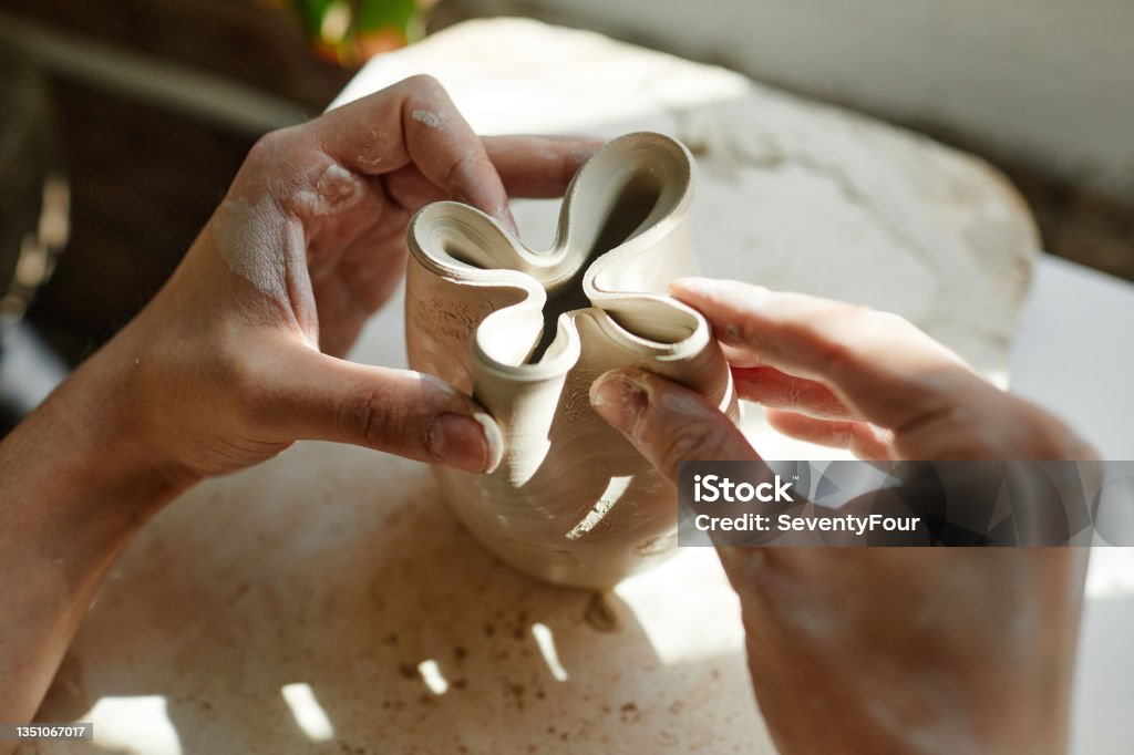 Artist Shaping Pottery Close Up Close up of female hands shaping ceramic bowl in sunlight, copy space Craftsperson Stock Photo