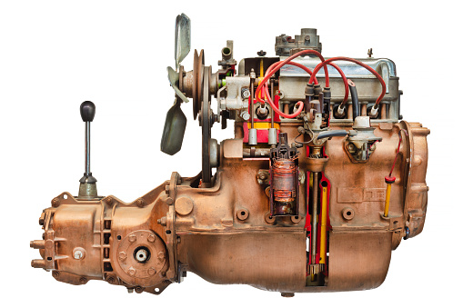 Side view of a disassembled vintage car engine with transmission and gear shift isolated on a white background