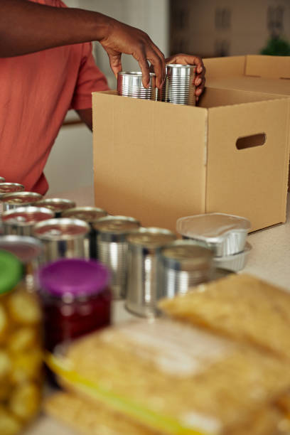 istock Unrecognizable man packing donation box with food 1351067132