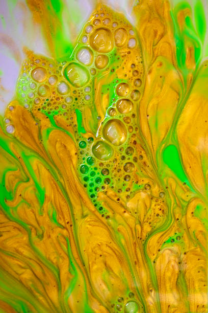 istock Fluid abstract acrylic and ink texture with colorful waves. Liquid paint and ink mixing. Red, yellow, green and metallic color. 1351067302