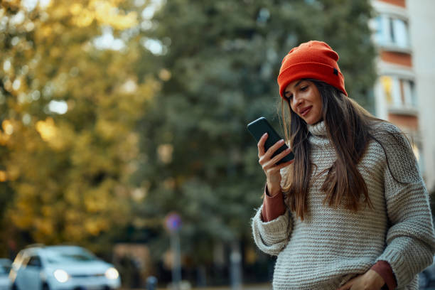 istock Beautiful woman using smart phone outdoors 1351067527