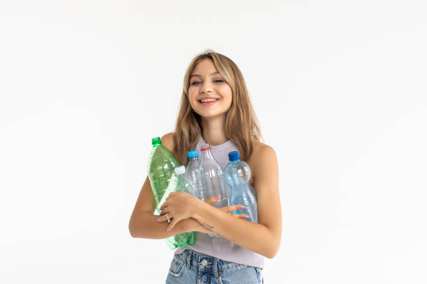 istock Young pretty woman carrying a plastic container full with empty recyclable plastic. Recycling concept 1351070097