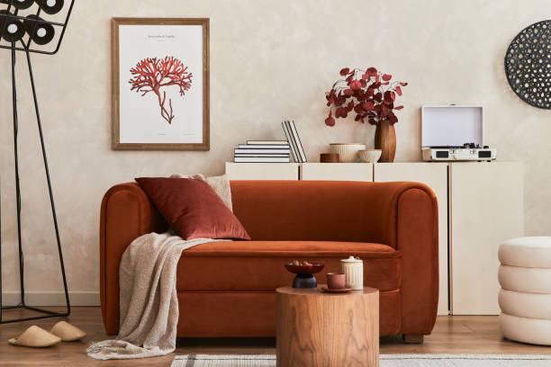 istock Creative composition of stylish living room interior with mock up poster frame, orange sofa, beige commode, coffee table and stylish personal accessories. Artistic space. Template. 1351070470