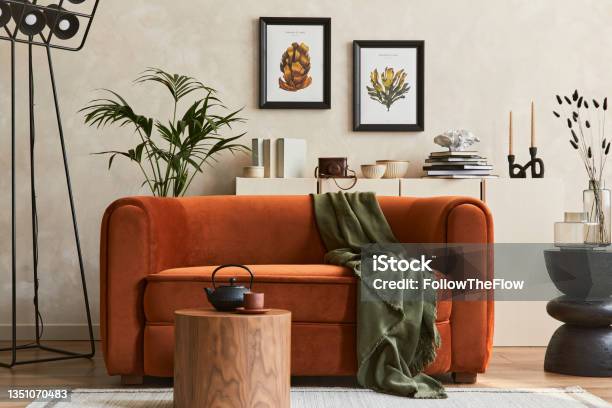 Creative Composition Of Stylish Living Room Interior With Mock Up Poster Frame Orange Sofa Beige Commode Coffee Table And Stylish Personal Accessories Artistic Space Template Stock Photo - Download Image Now