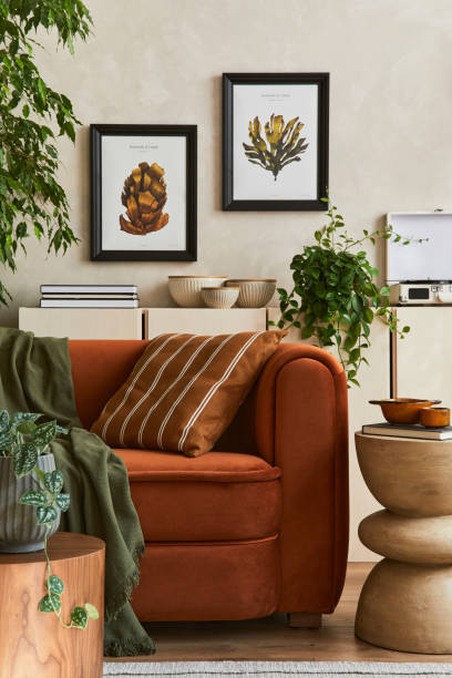 istock Creative composition of stylish living room interior with mock up poster frame, orange sofa, beige commode, coffee table and stylish personal accessories. Artistic space. Template. 1351070486