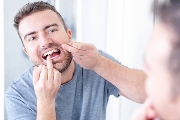 istock Man and oral hygiene routine using dental floss 1351071170