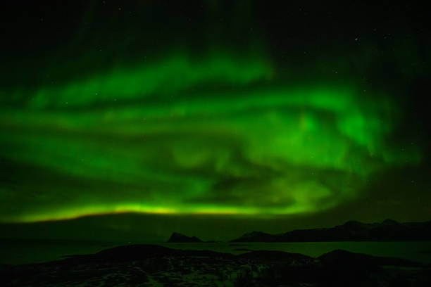 istock Aurora Borealis in the night sky over mountains silhouettes 1351071866