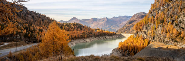 istock Panorama mountain range and autumn valley with conifers and lake 1351072471