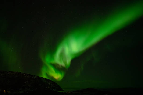 istock Aurora Borealis in the night sky over mountains silhouettes 1351072529