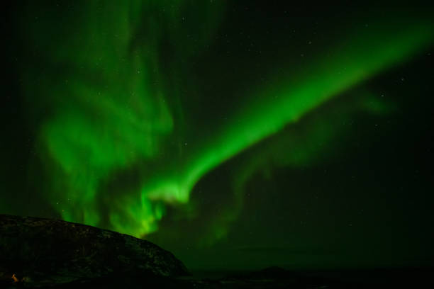 istock Aurora Borealis in the night sky over mountains silhouettes 1351072531
