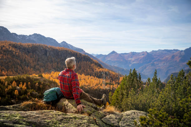 homme mûr se reposant sur le sommet de la montagne, vallée de la montagne d’automne - été indien photos et images de collection