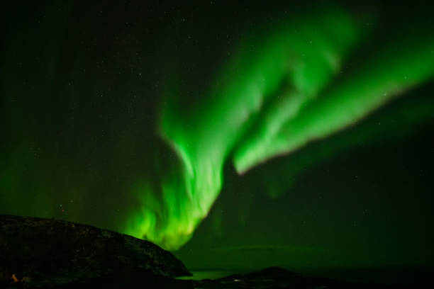 istock Aurora Borealis in the night sky over mountains silhouettes 1351072605
