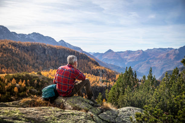 istock Hiker resting on the mountain peak, autumn mountain valley 1351072626