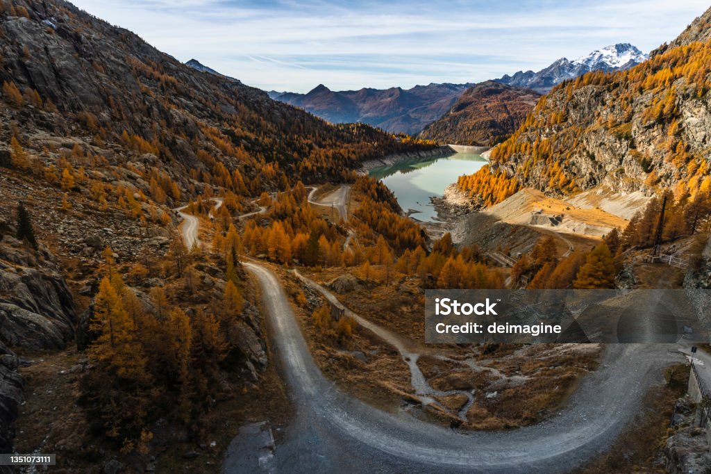 Country road in autumn valley Country road in autumn valley with lake mountain Mountain Stock Photo