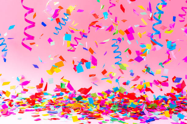 istock Multicolored falling confetti and streamers on pink background 1351073192