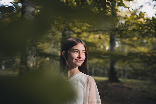 Relaxed Hispanic model outdoors in natural light sitting on a tree stub